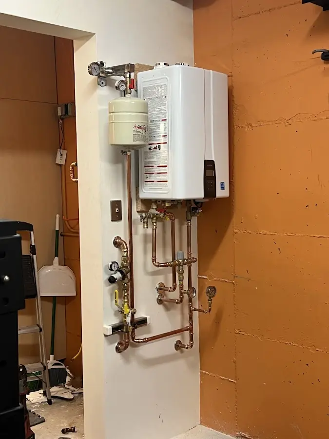 Plumbing technician inspecting water heater connections in Holbrook